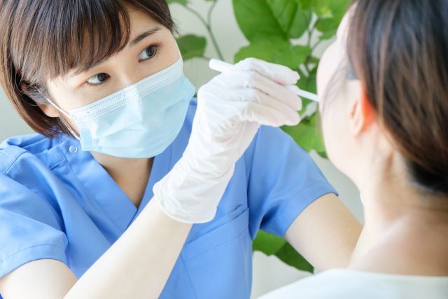 患者の口内を確認する女性歯科医師